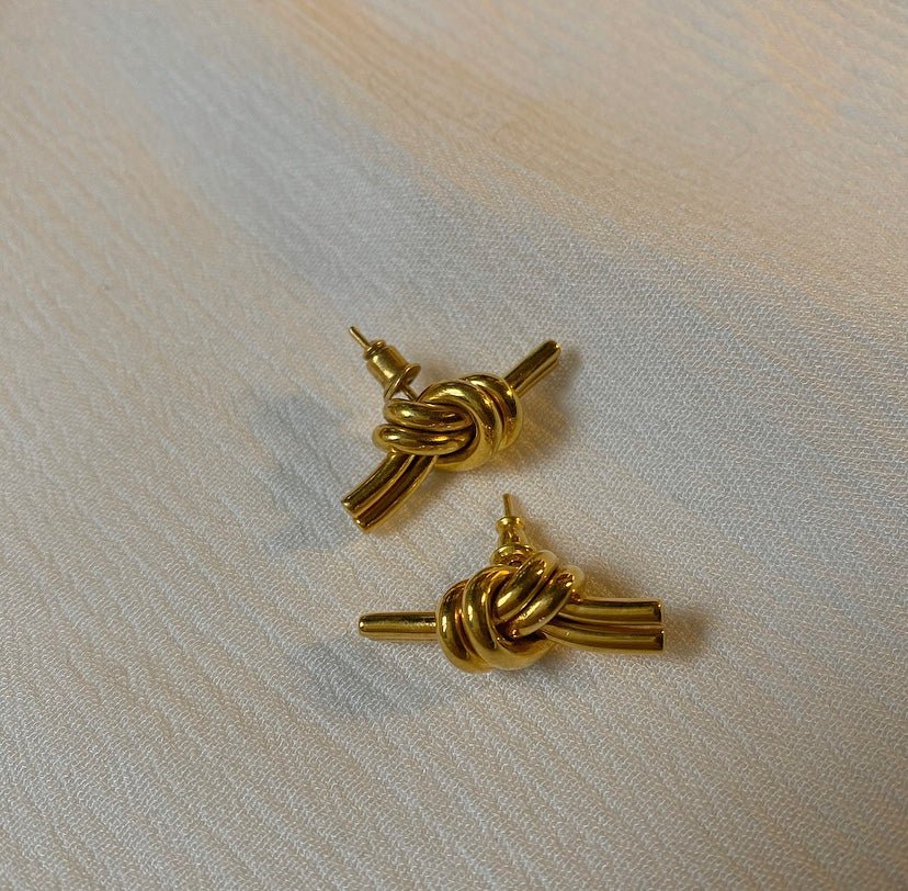 KAEN gold earrings styled in a flat lay, perfect for dressing up or keeping it casual.