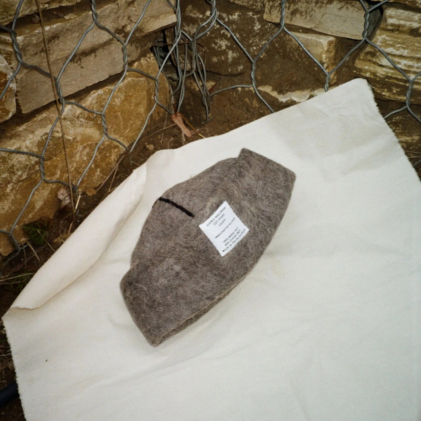 Folded Dust wool felt hat in earthy tones, highlighting fine stitching and craftsmanship.