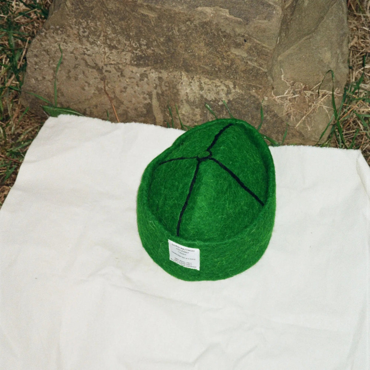 Detailed view of Forrest green hatâ€™s stitching and craftsmanship