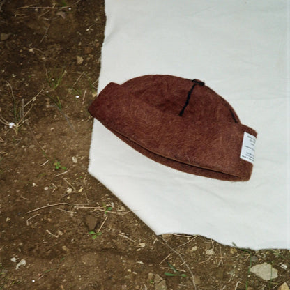 Folded Mocha wool felt hat, highlighting its warm tones and precision craftsmanship