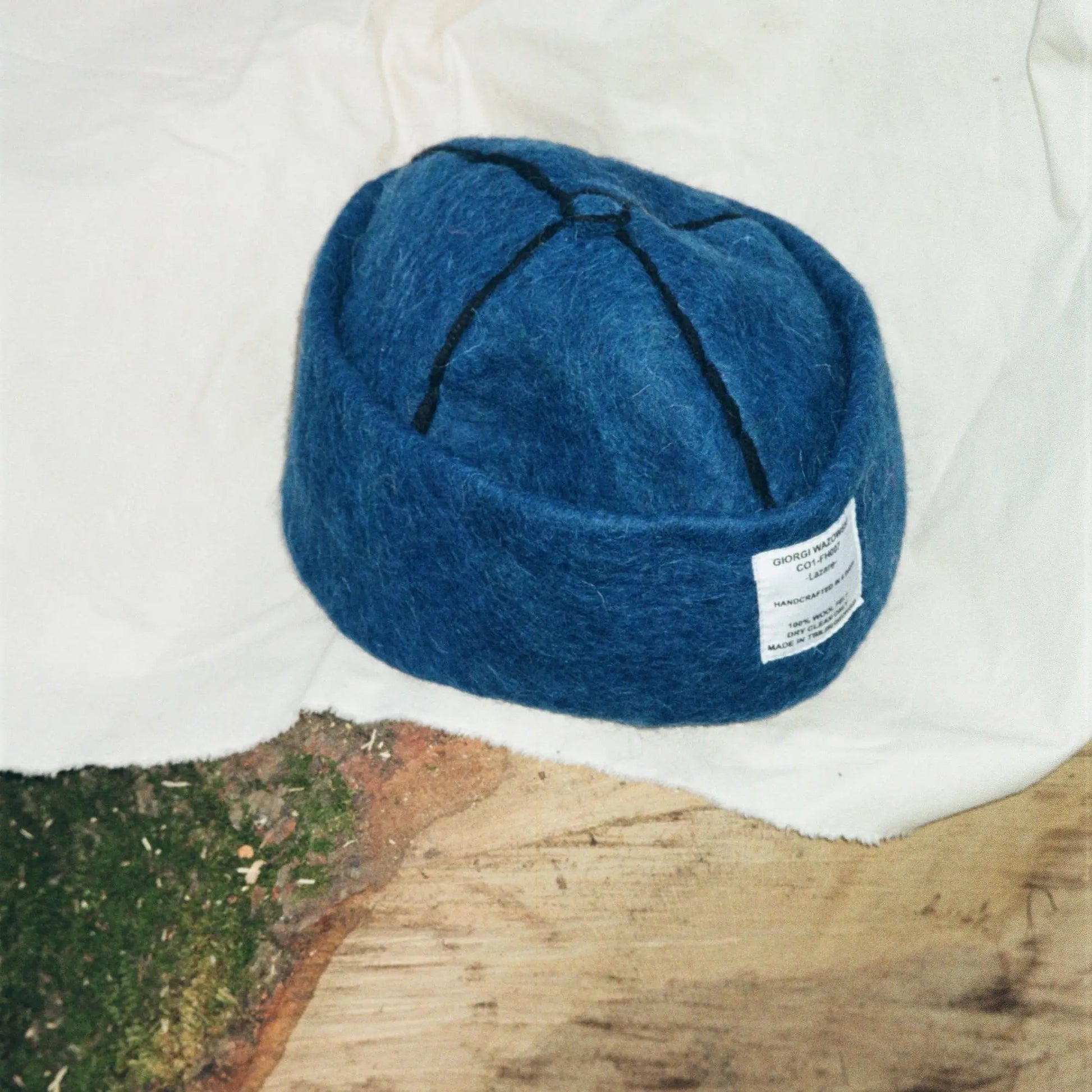 Detailed view of Denim hat’s stitching and wool label by Giorgi Wazowski